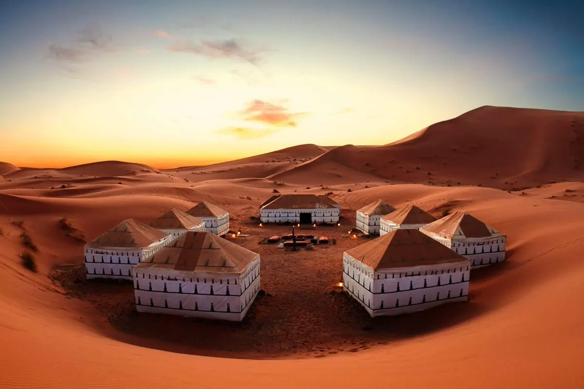 Luxury desert camp in Merzouga at dusk